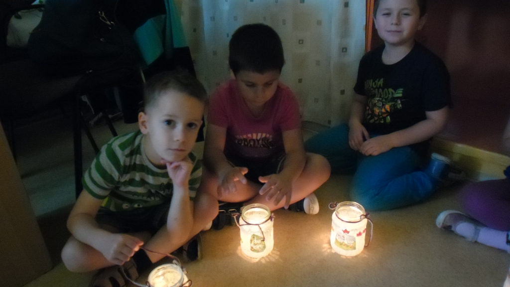 Három kisgyermek világító lámpásokkal