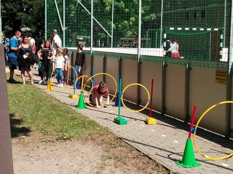 Gyerekek karikákon bújnak az udvaron