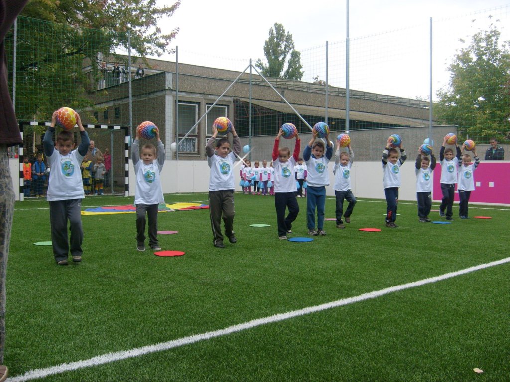 Gyerekek focipályán ladbát tartanak a fejük felett